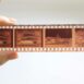 Detailed close-up photo of a film negative strip held by a person's hand, showcasing traditional photography.
